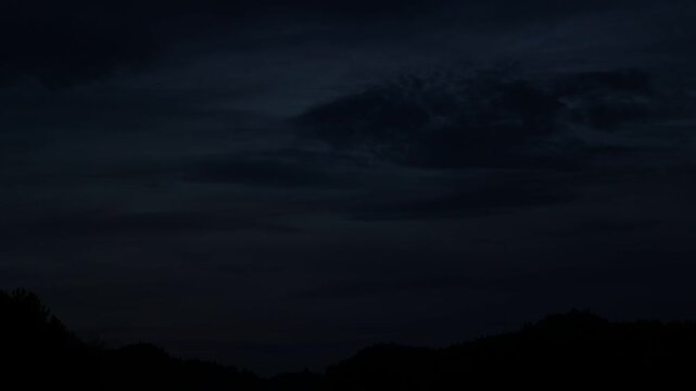 Beautiful sunset glow over distant mountains with drifting clouds shot in smooth timelapse for natural visual clips