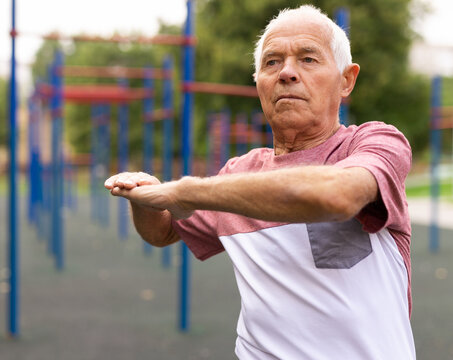 Sports grandfather doing fitness outdoors in park