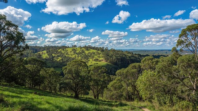 Lush green landscape with trees and rolling hills under a partly cloudy sky.