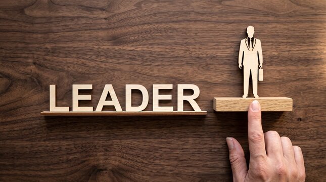 Leadership concept with wooden text and businessman figure, finger lifting leader on pedestal, corporate management and career growth metaphor