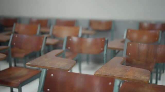 Interior of an empty school classroom featuring rows of wooden desks and chairs prepared for students. Suitable for education, school facilities, academic environment, classroom organization, learning