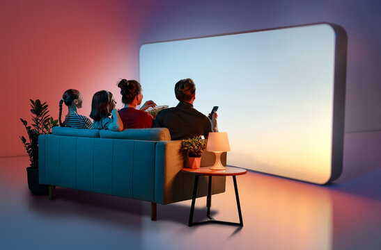 Happy Family Enjoying Movie Night at Home with Large Screen