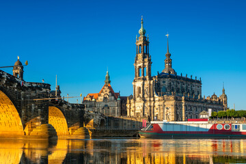Fototapeta premium Augustus Bridge and Cathedral of the Holy Trinity or Hofkirche with reflections in the river Elbe. Dresden, Saxony, Germany