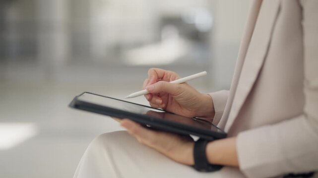 Business professional reviews digital documents with a tablet and stylus in a modern office. Ideal for concepts of electronic records, business management, digital transformation, workflow optimizatio