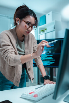 Women software developer using digital pen while reviewing source code on desktop computer in office, representing engineering, programming, code review, technology, innovation, IT productivity.