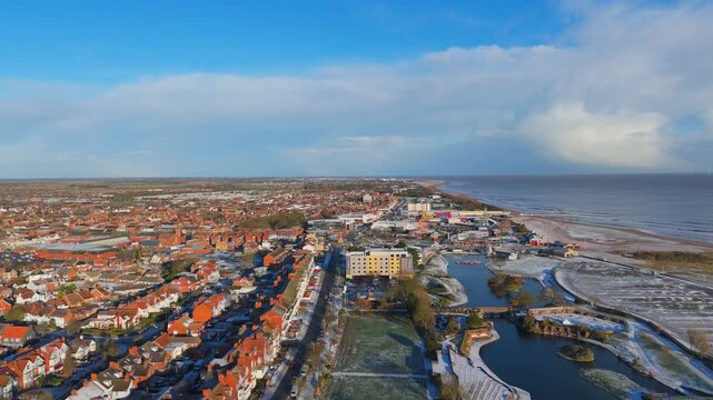 Aerial shot captures a snowy coastal city. rural landscape, Wainfleet, Village, Skegness in morning sunrise wintertime.