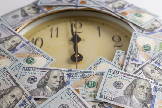Vintage round wall clock framed with US one hundred dollar bills concept of time is money