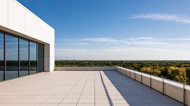 Modern building terrace overlooks expansive green forest under a clear blue sky