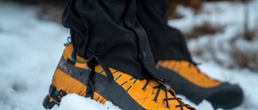 Closeup of mountaineering boots with snow gaiters for winter hiking and climbing.