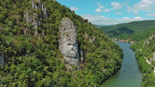 Aerial view of stone carved statue portrait of ancient dacian king Decebal. Sculpture located on shore of Danube River, Romania, 4k
