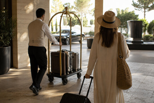 Luxury hotel guest arriving with luggage and bell service
