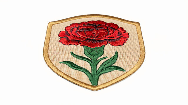 Red rose embroidered patch on beige background with floral design, textile art