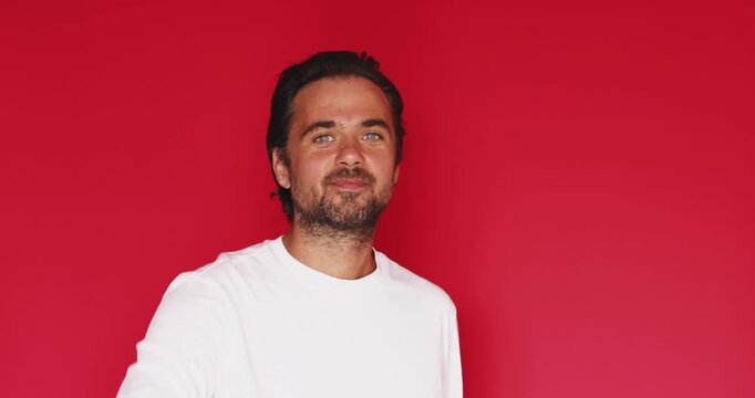 Handsome bearded man wearing a casual white t shirt looking directly at camera and making a zip mouth gesture with his fingers and throwing away imaginary key to indicate silence secrecy confidential