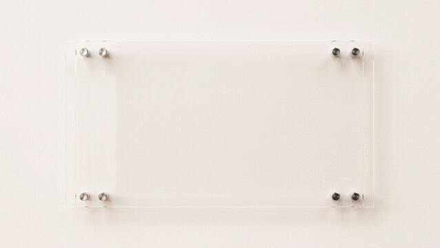 Frosted glass whiteboard with metal frame and four corner pins on a white wall