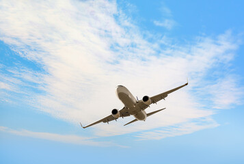 Fototapeta premium White passenger airplane flying in the sky amazing clouds in the background - Travel by air transport