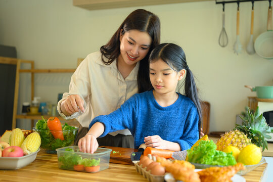 Mother and Daughter Preparing Fresh Vegetables Together in a Bright Home Kitchen
