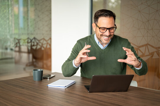 Male entrepreneur communicating during online video call meeting, gesturing with hands while discussing strategy and presenting ideas to remote team members