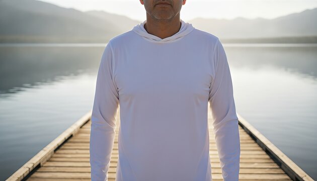 Middle aged Hispanic man wearing a blank white hooded fishing jersey on a sun draped wooden lake pier