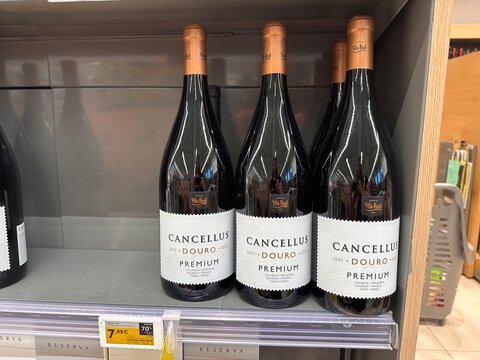 Cancellus Douro portuguese wine premium red wine bottles grouped on a supermarket shelf beside shopping baskets, showing Portuguese wine branding, 4 April 2026, Sintra, Portugal
