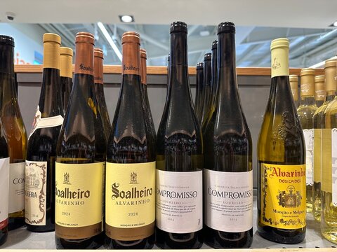 Portuguese white wine bottles including Soalheiro Alvarinho and Compromisso Loureiro arranged in a supermarket retail display of regional vintages for shoppers, 4 April 2026, Sintra, Portugal