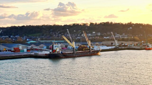 Cargo ship docked at industrial port on Seine estuary in Normandy, France. Maritime freight, cargo handling and port logistics