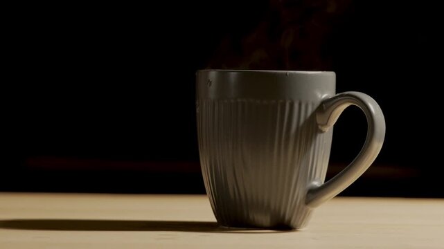 Steam rising from grey ceramic mug on wooden table close up