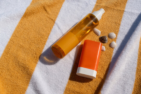 Sunscreen and Shells on a Beach Towel
