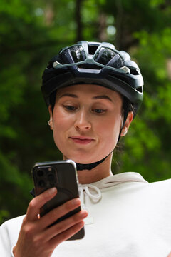 Cyclist checking navigation or messages on her smartphone during 