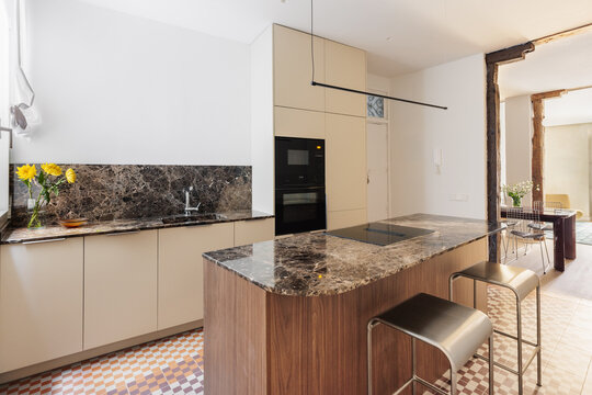 Full kitchen with island, marble counter and dining room vista