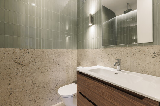 Bathroom wide view with sage green tiles and terrazzo floor
