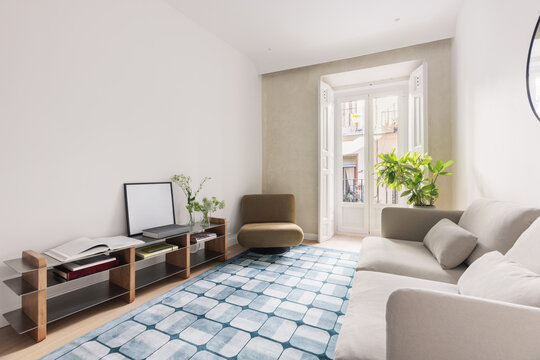 Living room wide view with bookshelf, sofa and balcony