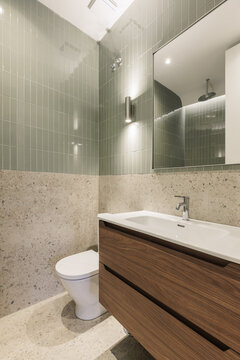 Bathroom with sage green tiles, terrazzo and walnut vanity