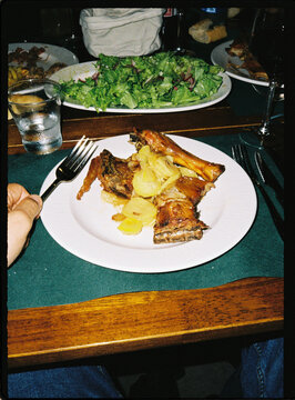 Person holding fork enjoying roasted meat dinner