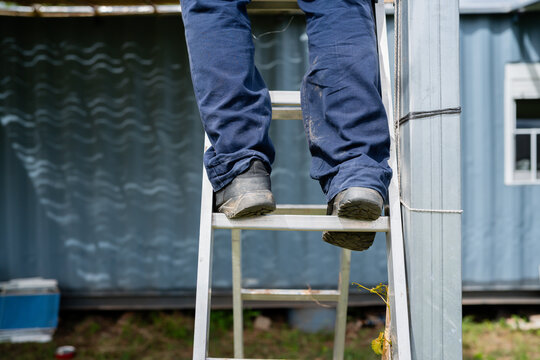 Worker climbing ladder during construction