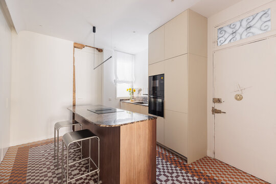 Kitchen with marble island and beige cabinetry