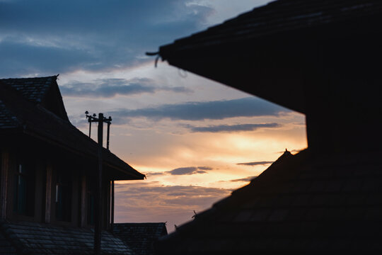 Sunset Sky Framed by Traditional Village Rooftops