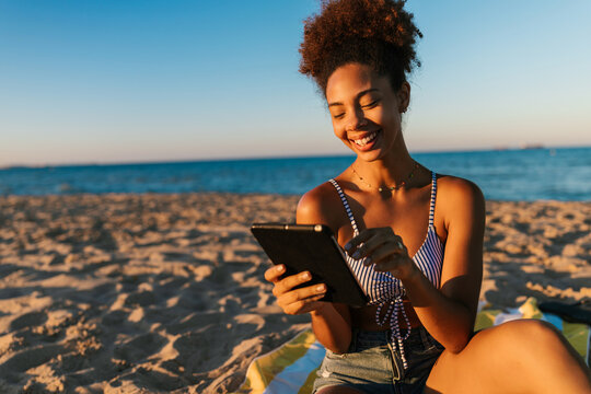Happy woman using tablet on beach vacation
