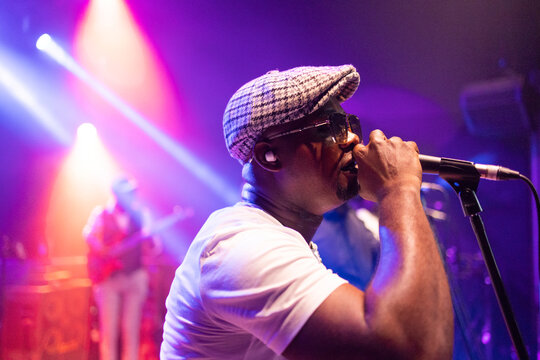 Male singer performing song on stage, live music concert