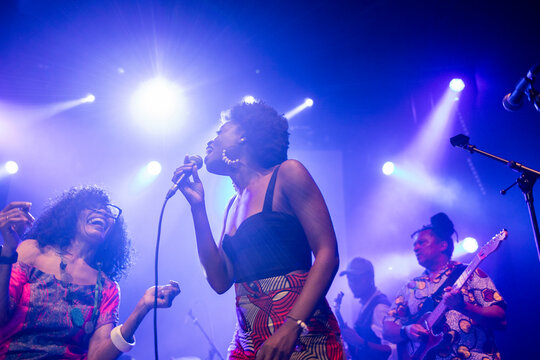 Joyful women singing powerful music on concert stage