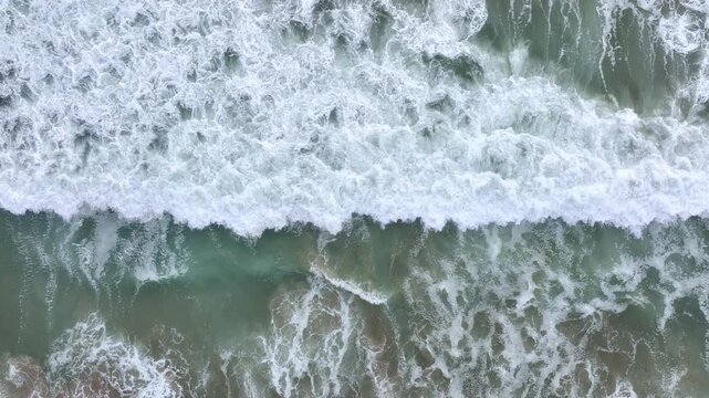 Ocean water flowing forward. Sea surf washing the beach. Ocean waves forming patterns. Sea movement along coastline. Ocean waves rolling steadily. Sea water shifting in motion.