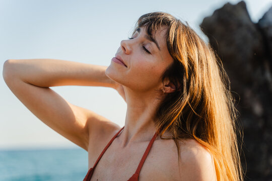 Joyful woman enjoying the sunshine by the beach