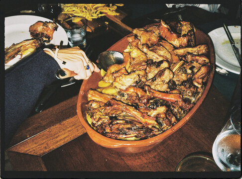 Person enjoying large roasted meat feast at dinner