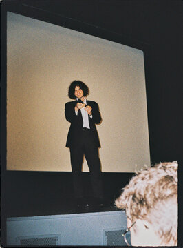 Man speaking on stage at a film premiere