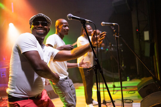 African male singer performing live music on stage