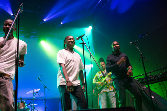Music band performing live concert on illuminated stage
