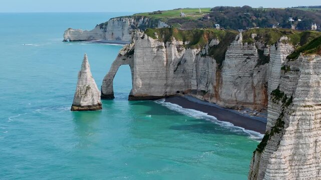 Aerial drone view of Etretat, France, with coastal limestone cliffs, natural arch and English Channel shoreline. Famous Normandy travel destination