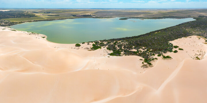 Sand dunes surrounding a green coastal lagoon