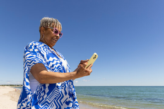 Senior Black Couple cell phone beach 
