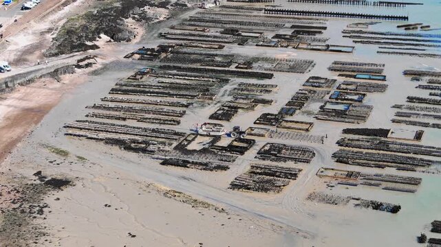 Drone aerial of Cancale oyster beds and farming infrastructure, shellfish cultivation area in northwestern France