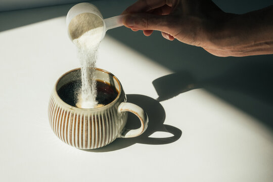 Pouring Collagen Powder into Coffee